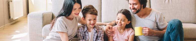 Familie, 2 ouders, 2 kinderen lezen samen in een boek 