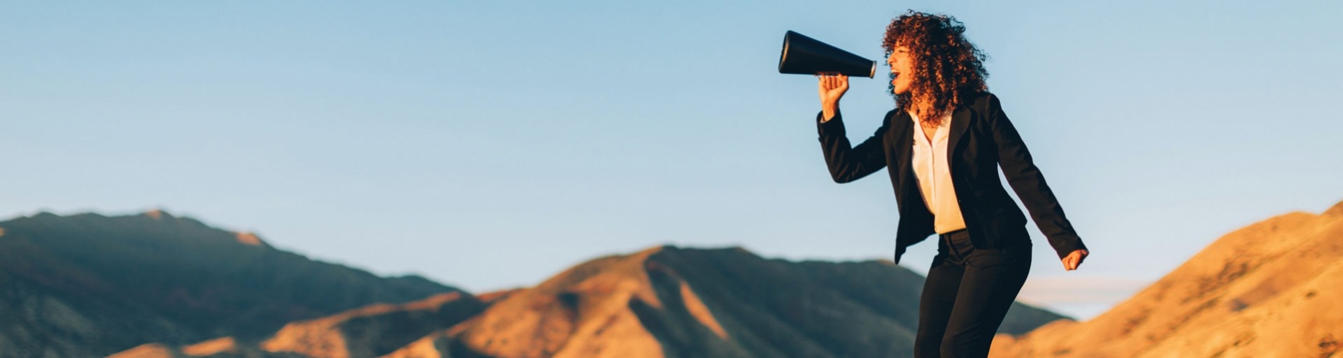 Zakenvrouw schreeuwt door een megaphone